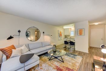 Living Room with hardwood inspired flooring, White Couch and coffee table. at Renaissance Park Apartments, California, 95618